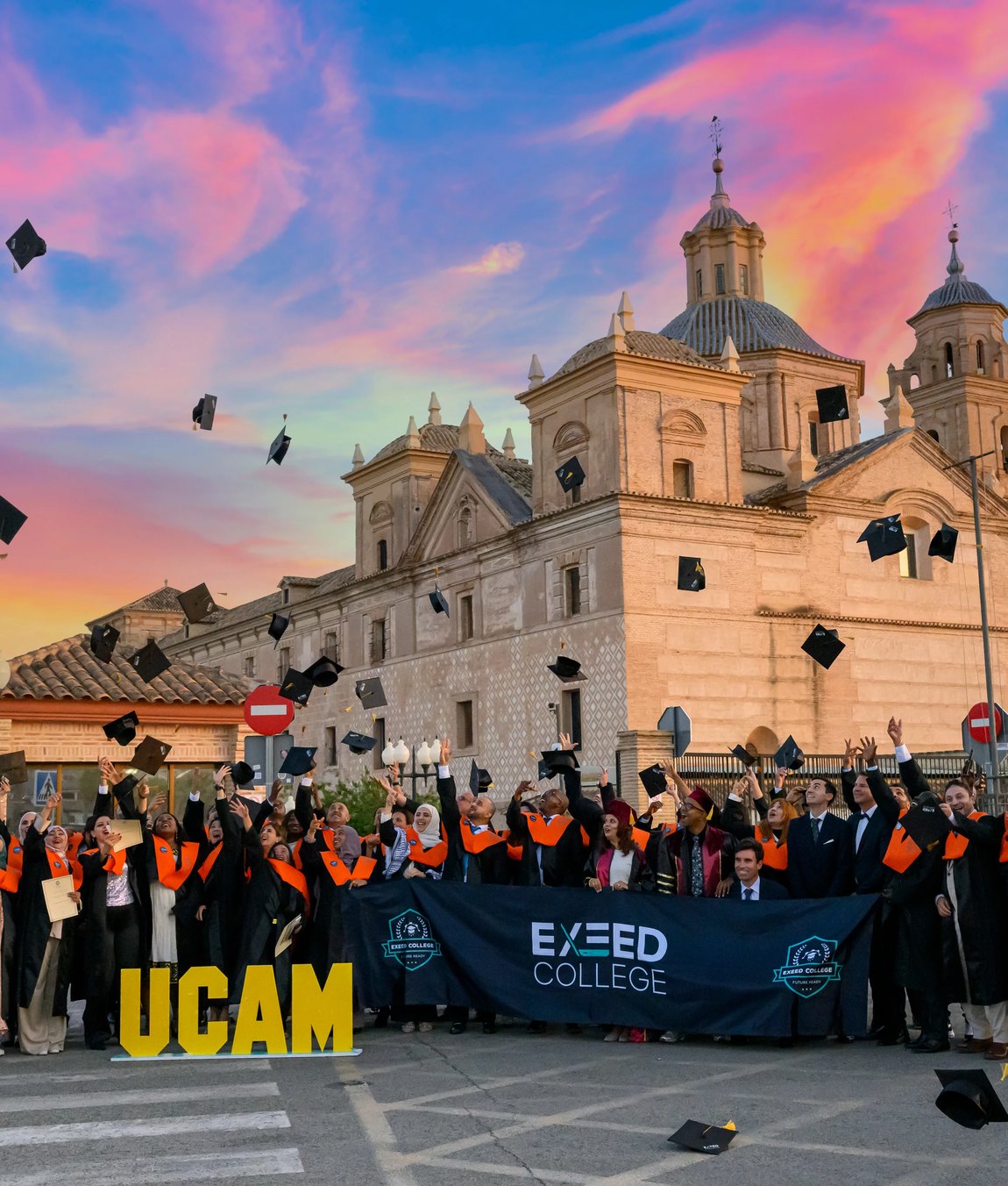 TAITO Education graduates throwing their caps outside UCAM, Universidad Cat&oacute;lica de Murcia